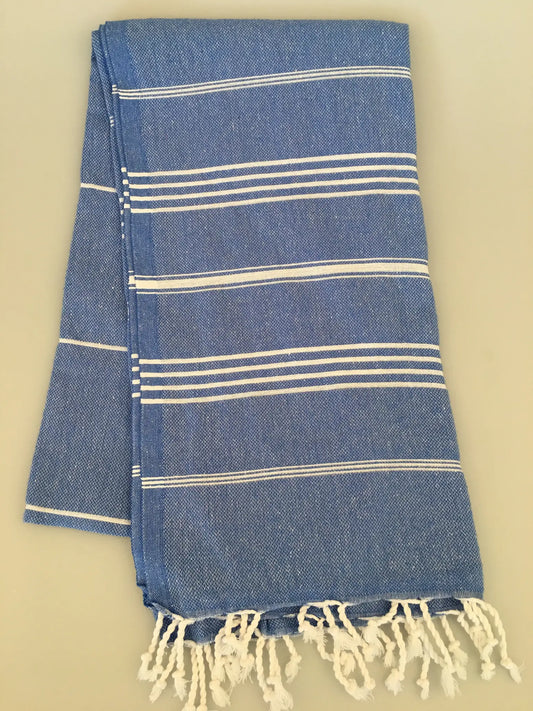 Blue and white striped Turkish towel with fringed ends, folded neatly on a light background.