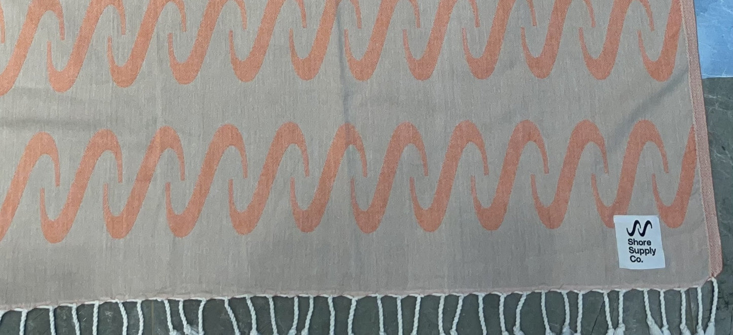 Jacquard-woven Turkish towel with wave pattern and Shore Supply Co. woven label, detail crop