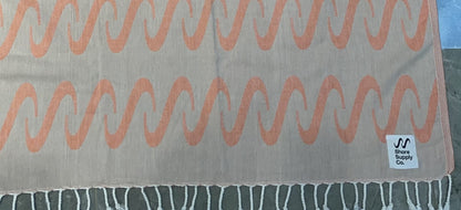 Jacquard-woven Turkish towel with wave pattern and Shore Supply Co. woven label, detail crop